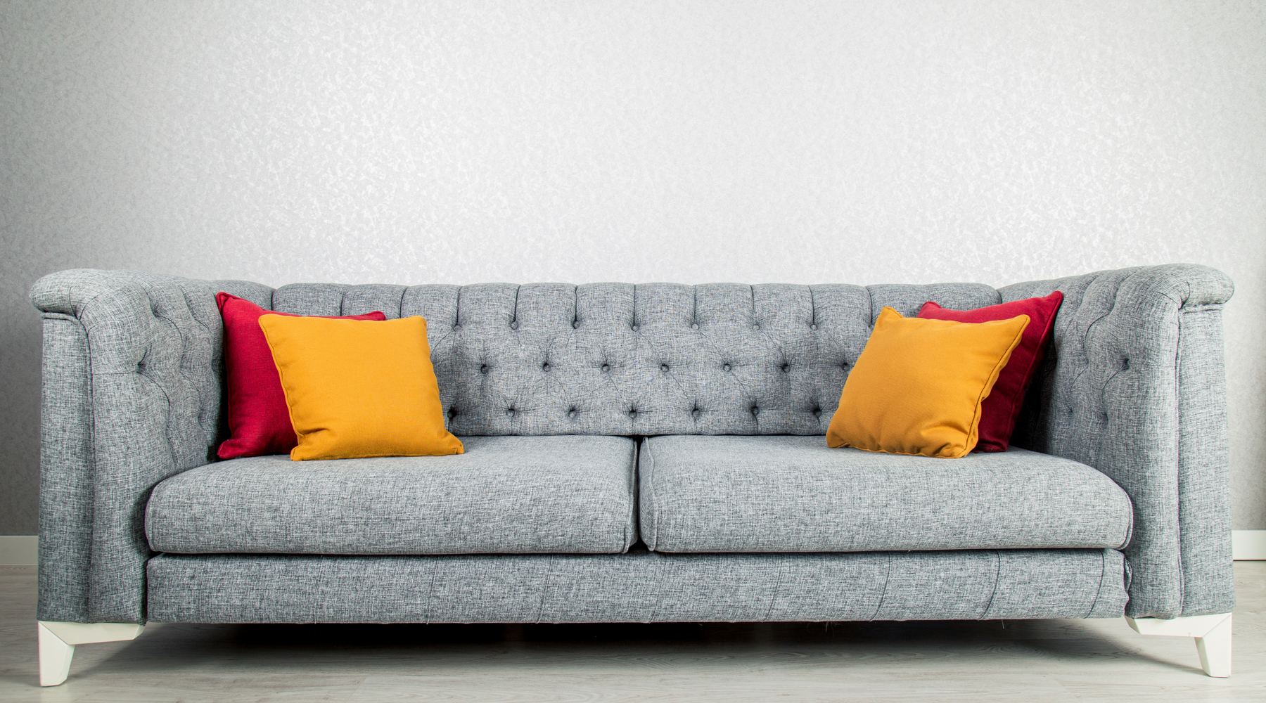 Country-styled tufted sofa with bold cushions